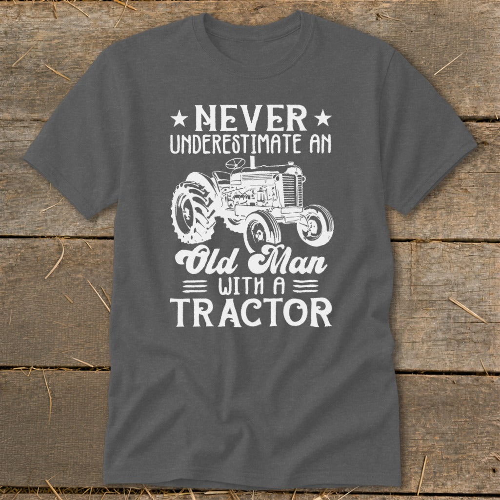 Gray t-shirt with white text and tractor graphic saying "Never Underestimate an Old Man with a Tractor".