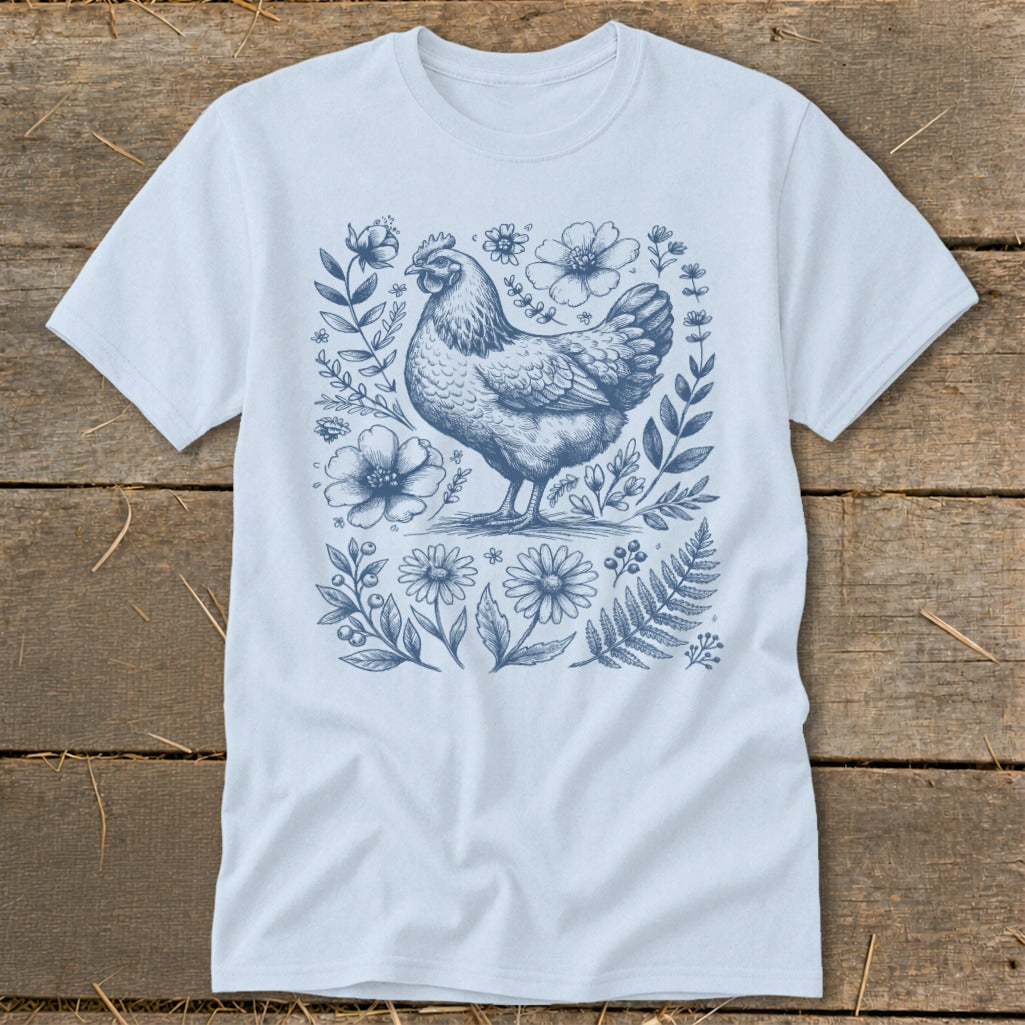 Light blue t-shirt with a blue line drawing of a chicken surrounded by flowers.