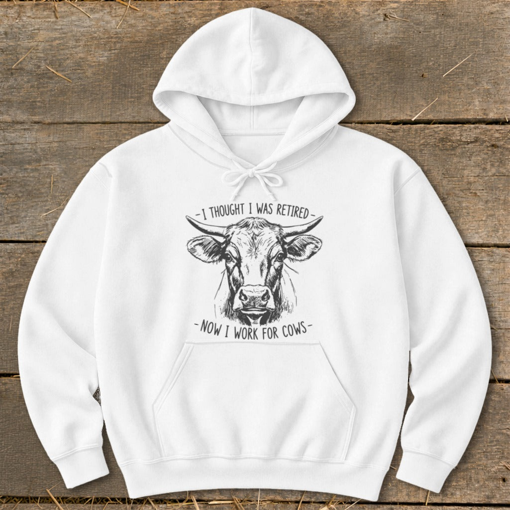 White hoodie with sketch of a bull and text: "I THOUGHT I WAS RETIRED - NOW I WORK FOR COWS".
