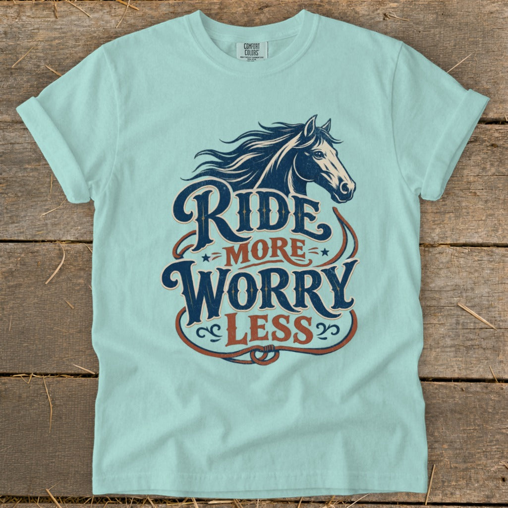 Light blue t-shirt with "Ride More Worry Less" text and horse graphic.