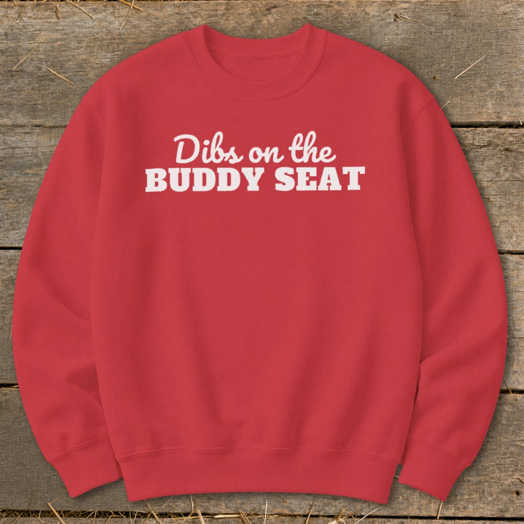 Red crewneck sweatshirt with white text reading "Dibs on the BUDDY SEAT".