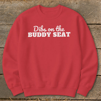 Red crewneck sweatshirt with white text reading "Dibs on the BUDDY SEAT".