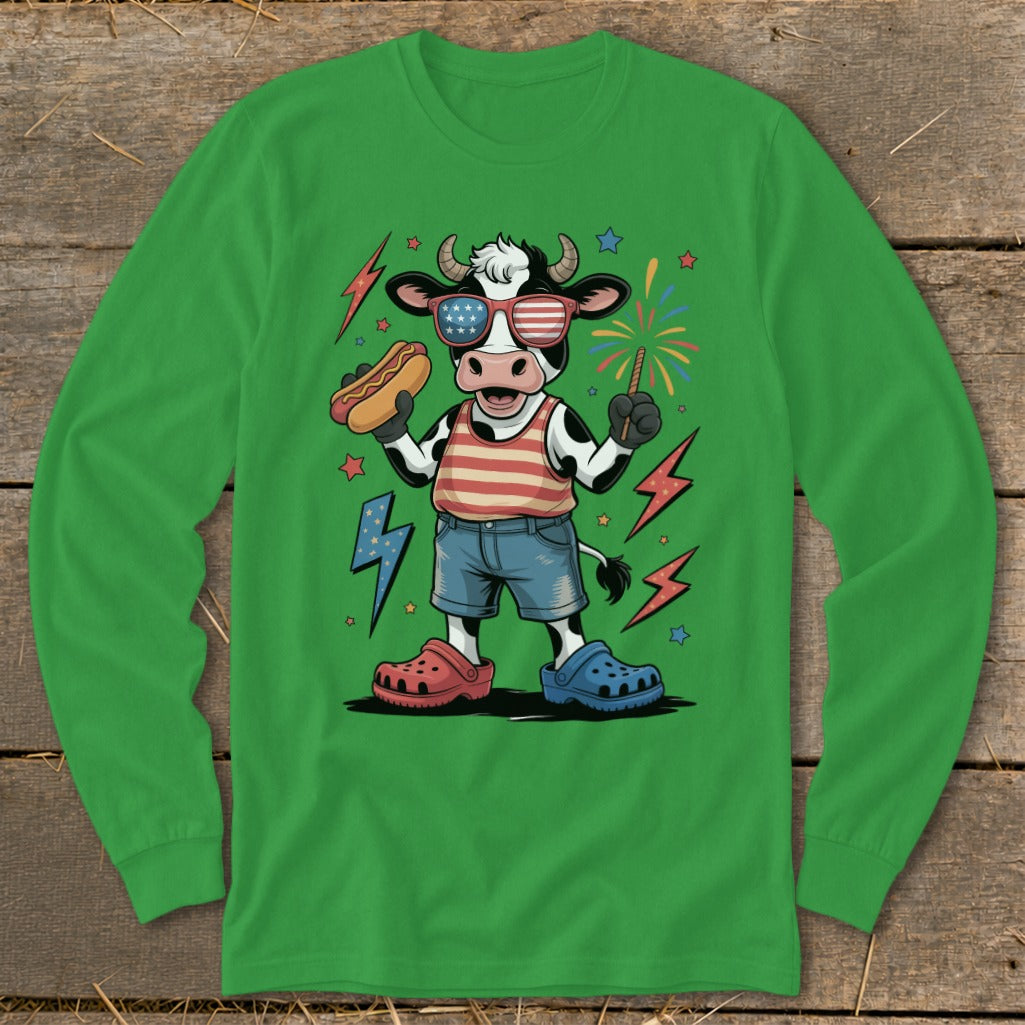 Cow wearing patriotic sunglasses and holding a hot dog with fireworks.