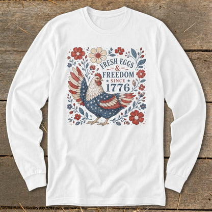 White long-sleeve shirt with a chicken and floral design reading "Fresh Eggs & Freedom Since 1776."