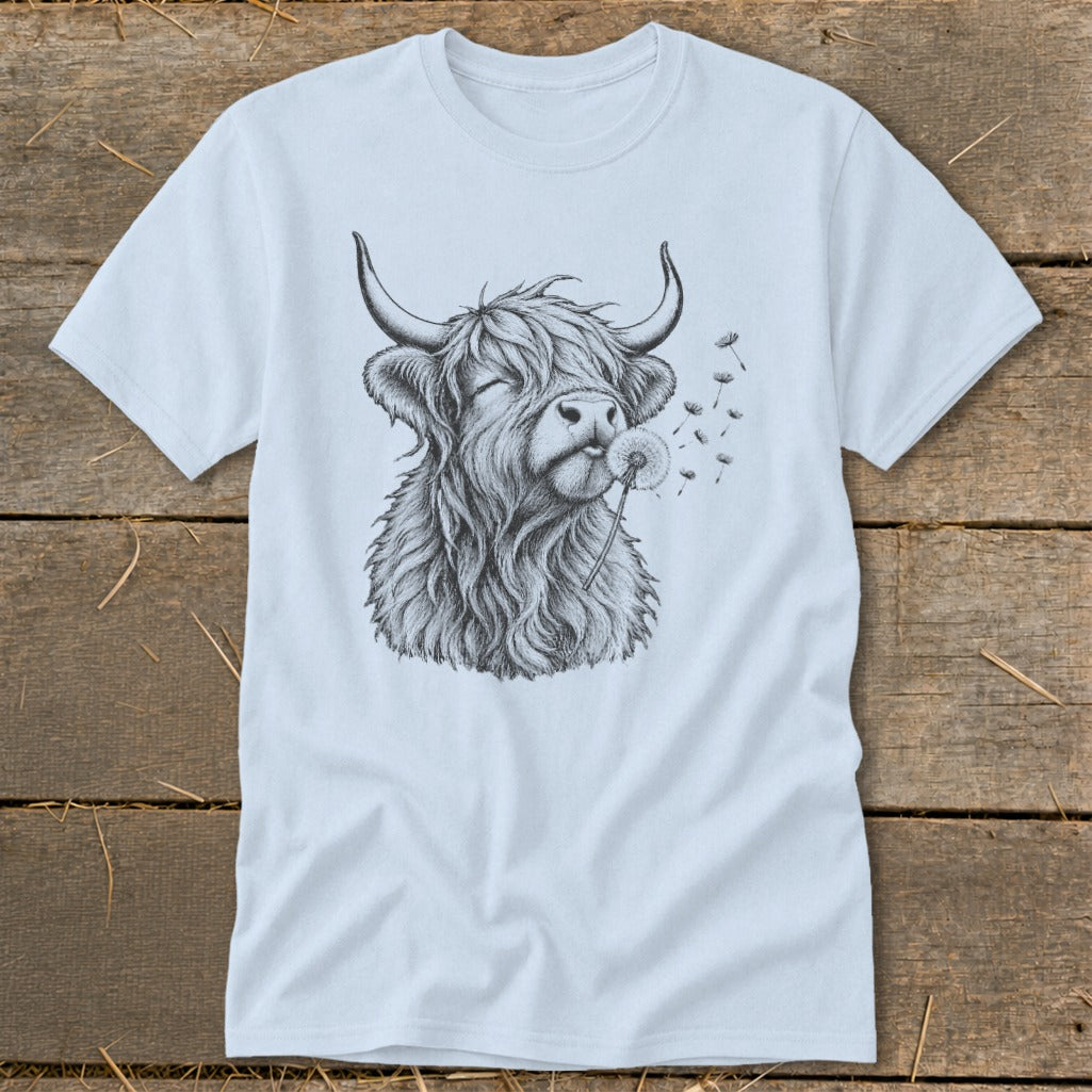 Highland cow sketch blowing dandelion seeds on a light blue t-shirt.