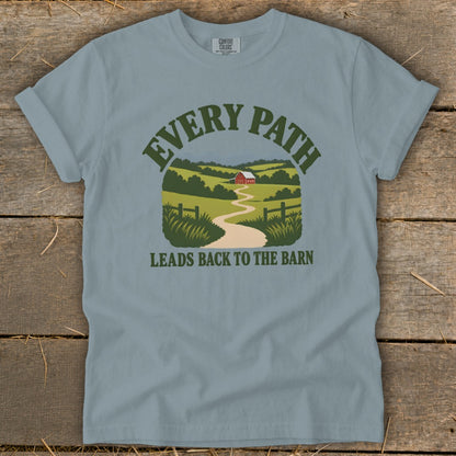 Light blue t-shirt with graphic of a winding path leading to a red barn and text "EVERY PATH LEADS BACK TO THE BARN".