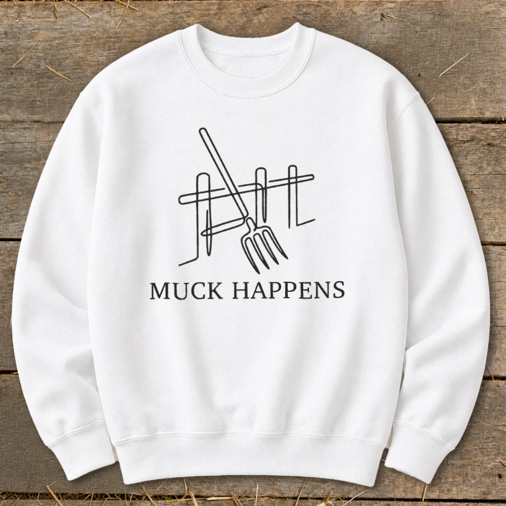 White sweatshirt with a black line drawing of a pitchfork and fence with text "MUCK HAPPENS".