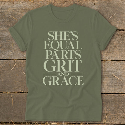 Olive green t-shirt with the text "SHE'S EQUAL PARTS GRIT AND GRACE"