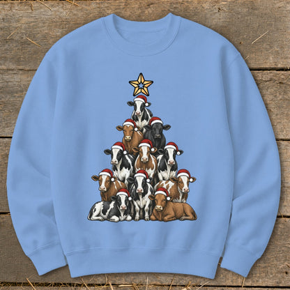 Light blue sweatshirt with cows arranged as a Christmas tree, topped with a star.