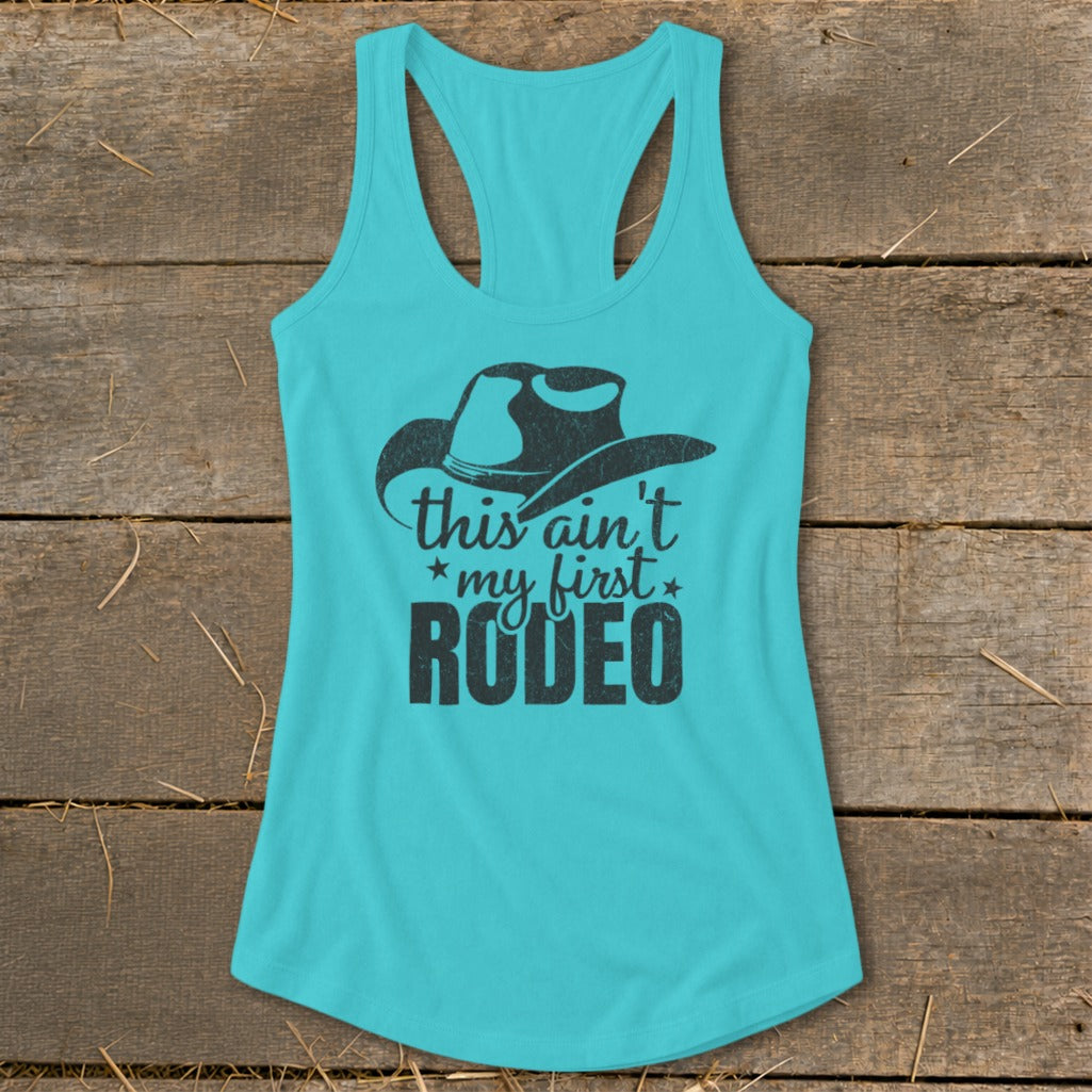Turquoise tank top with black cowboy hat graphic and text "this ain't my first RODEO".