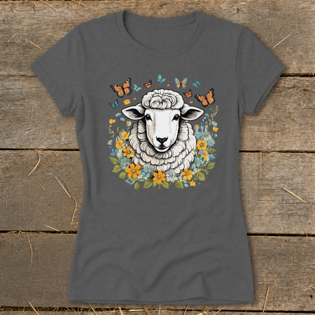 Sheep surrounded by colorful flowers and butterflies on a dark gray t-shirt.