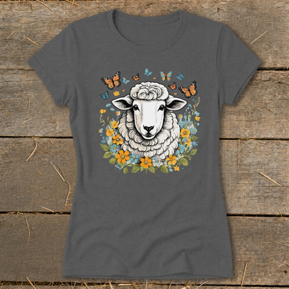 Sheep surrounded by colorful flowers and butterflies on a dark gray t-shirt.