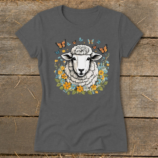 Sheep surrounded by colorful flowers and butterflies on a dark gray t-shirt.