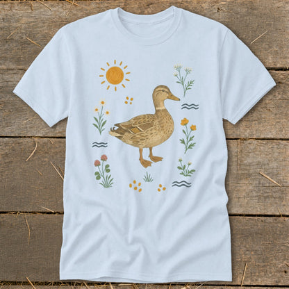 Light blue t-shirt with a watercolor illustration of a duck surrounded by flowers and sun.