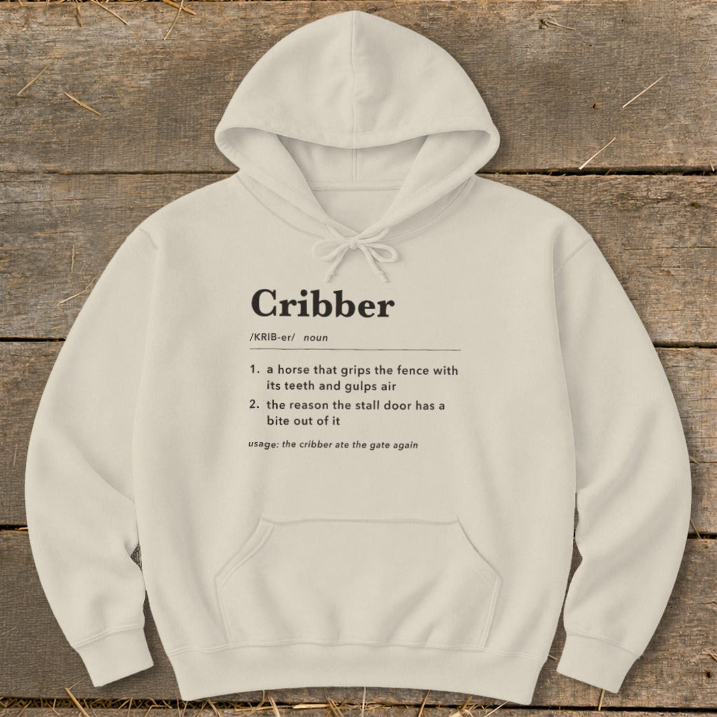 Cream-colored hooded sweatshirt with black text defining the word cribber displayed across the chest.