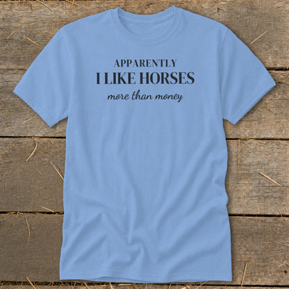 Light blue t-shirt with black text that reads "APPARENTLY I LIKE HORSES more than money."