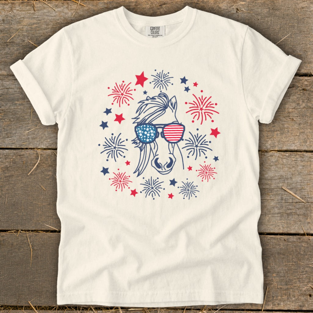 Cream t-shirt with horse wearing American flag sunglasses surrounded by fireworks.
