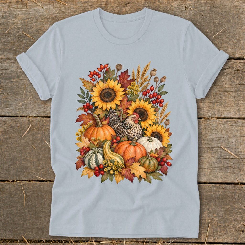 Light blue t-shirt with fall harvest graphic featuring pumpkins, sunflowers, chickens, and leaves.