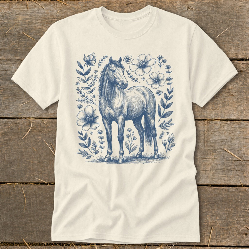 Cream t-shirt with blue horse and floral line art design.