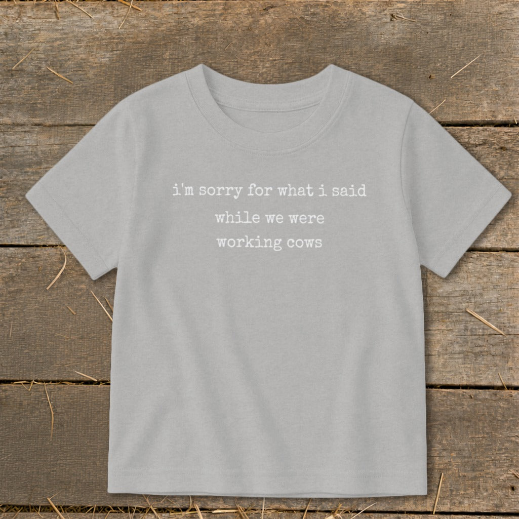 Light grey t-shirt with white text that reads "I'm sorry for what I said while we were working cows."
