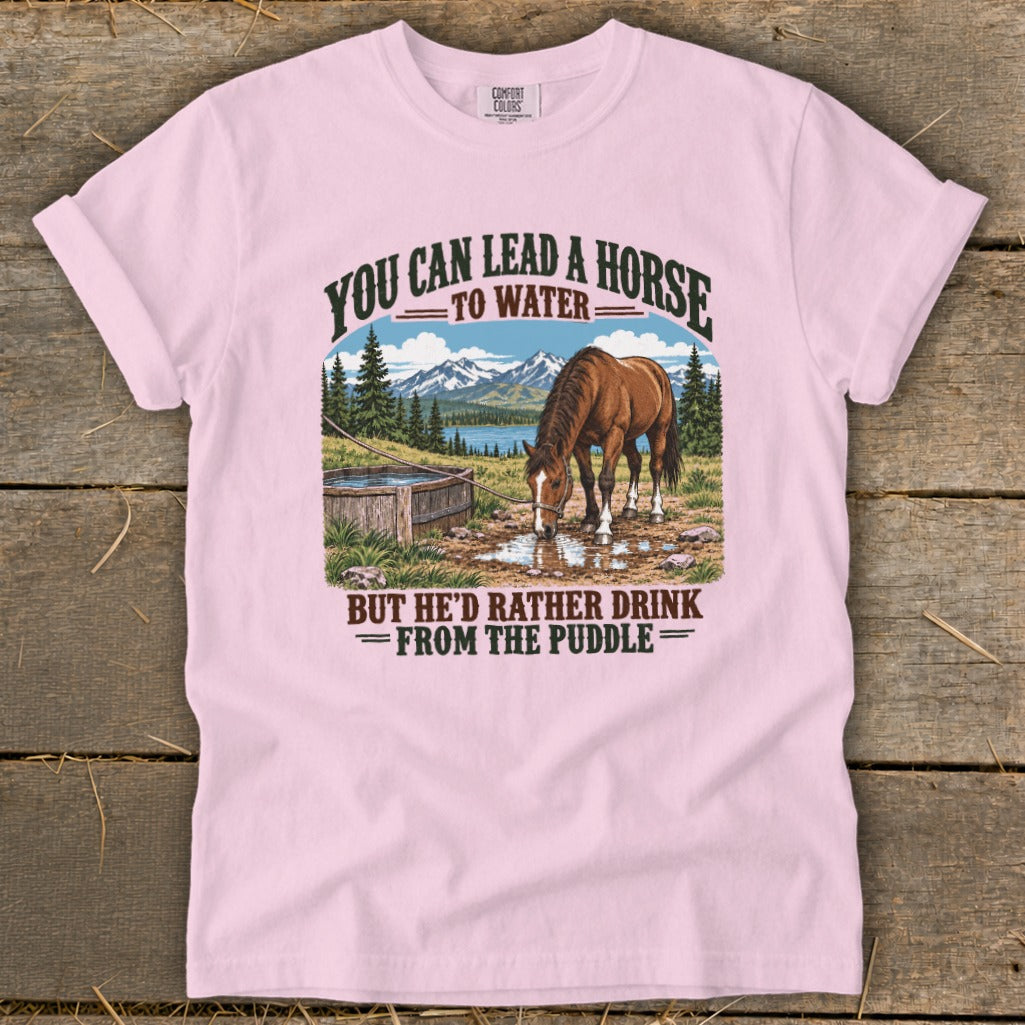 Pink crewneck t-shirt featuring graphic text and a horse drinking from a puddle.