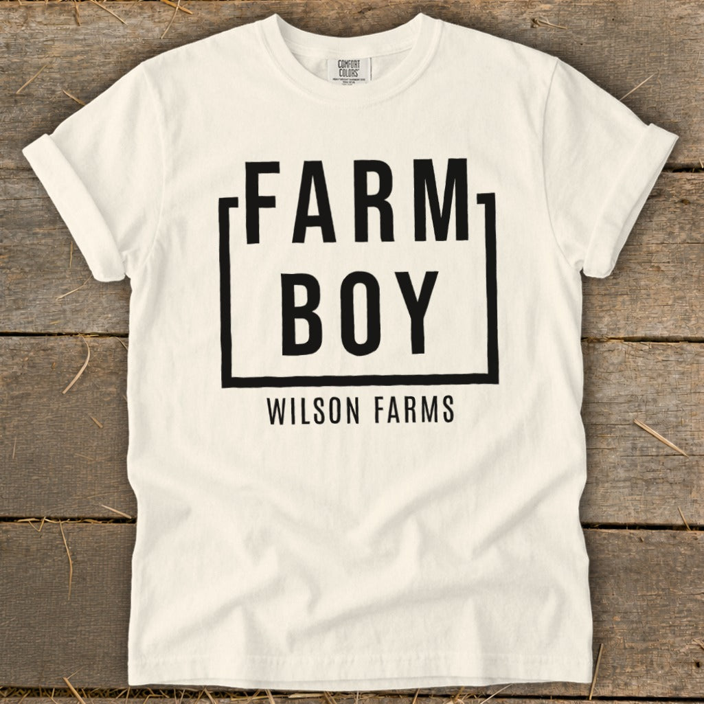 White t-shirt with "FARM BOY" and "WILSON FARMS" printed in black.