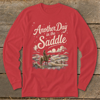 Red long sleeve shirt with graphic: "Another Day in the Saddle" and cowboy on horse.