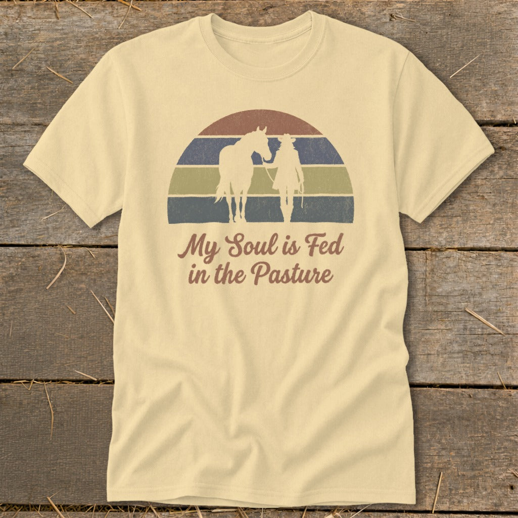 Yellow t-shirt with horse and rider graphic and text "My Soul is Fed in the Pasture."