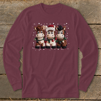 Three cartoon horses wearing Christmas lights and scarves on a maroon long-sleeve shirt.