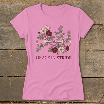 Pink t-shirt with floral print and equestrian bit, text "GRACE IN STRIDE".