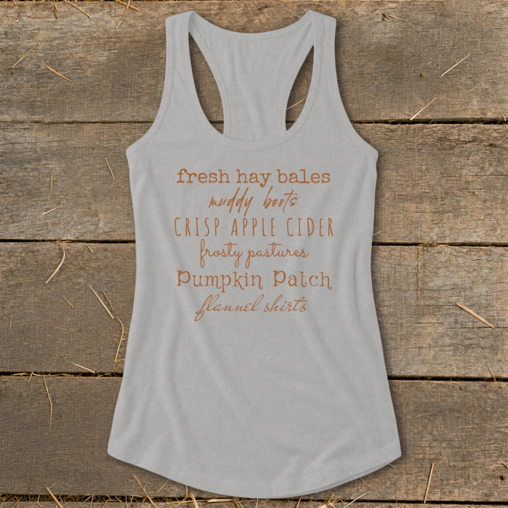 Grey tank top with list of fall items: fresh hay bales, muddy boots, crisp apple cider.