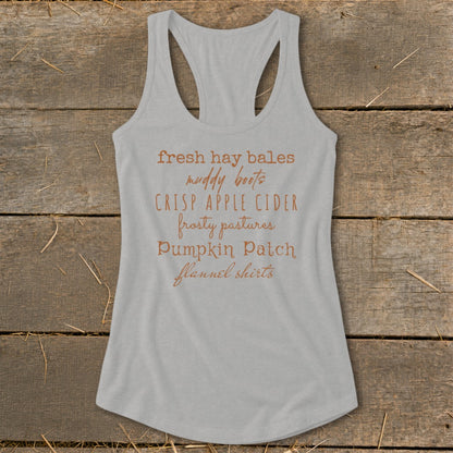 Grey tank top with list of fall items: fresh hay bales, muddy boots, crisp apple cider.