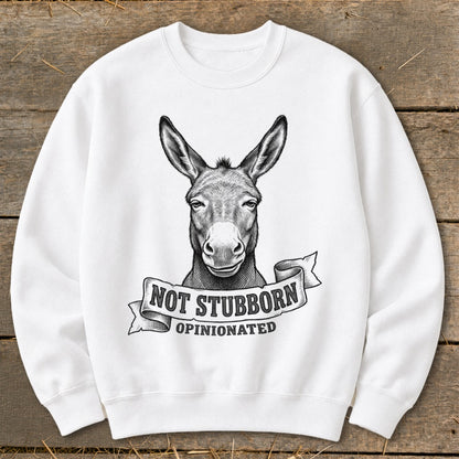 White sweatshirt with a black and white drawing of a donkey head above text reading "NOT STUBBORN OPINIONATED".