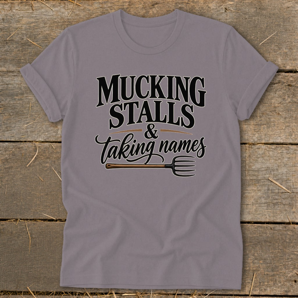 Grey t-shirt with "Mucking Stalls & Taking Names" text and pitchfork graphic.