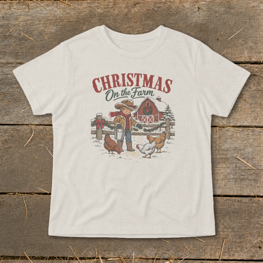 T-shirt graphic with "Christmas on the Farm" text, a boy feeding chickens by a barn.