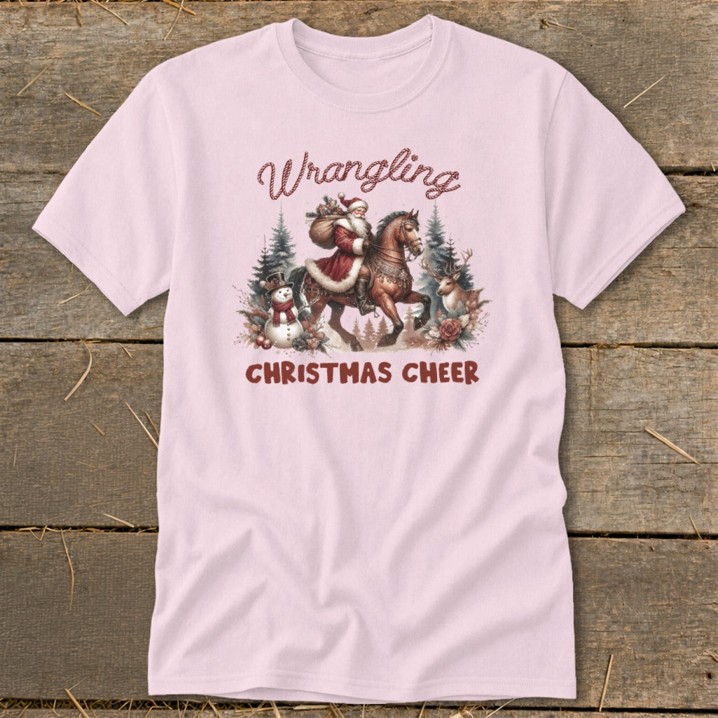 Pink t-shirt with "Wrangling Christmas Cheer" graphic featuring Santa on horseback.
