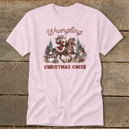 Pink t-shirt with "Wrangling Christmas Cheer" graphic featuring Santa on horseback.