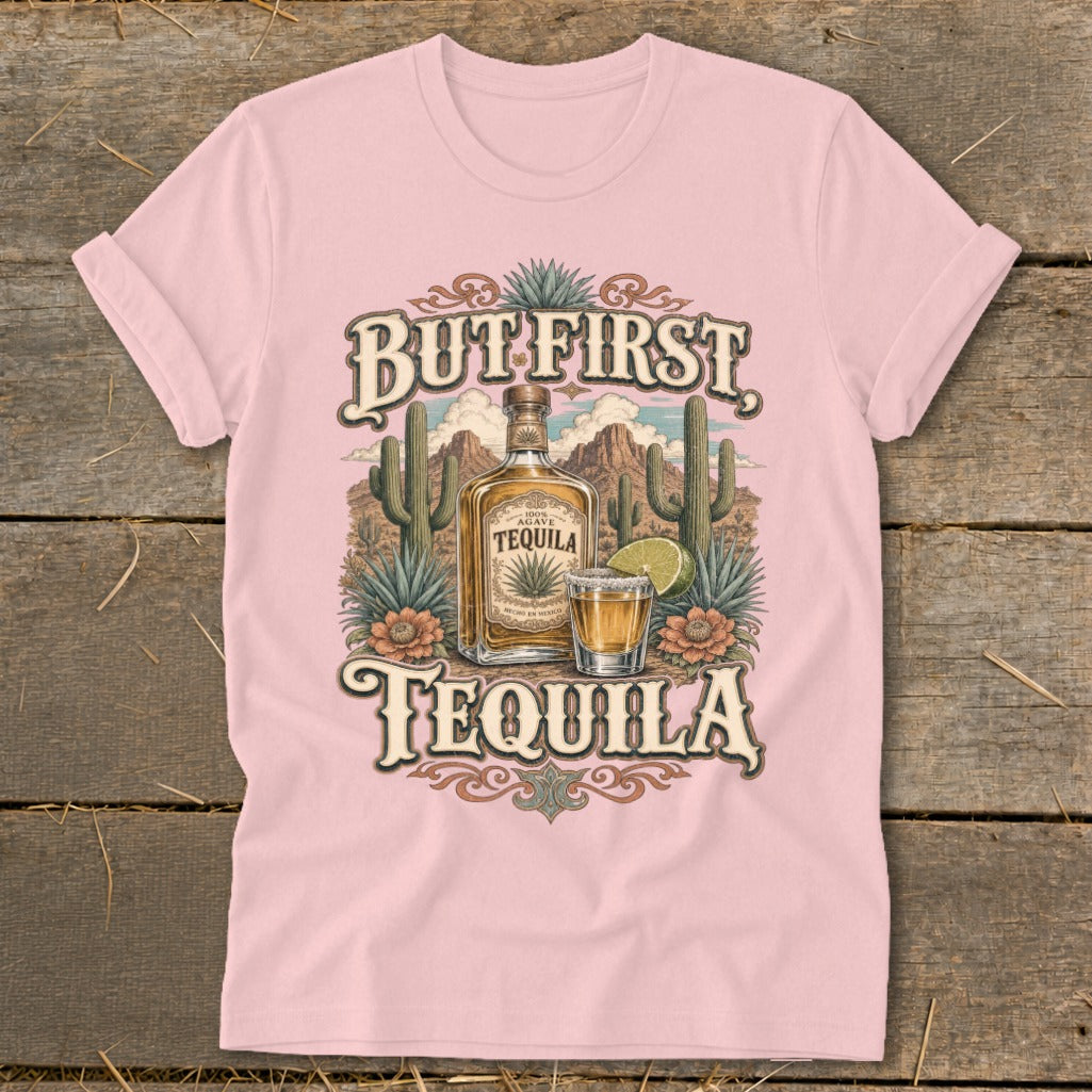 Pink t-shirt with "But First Tequila" graphic featuring a tequila bottle and shot.