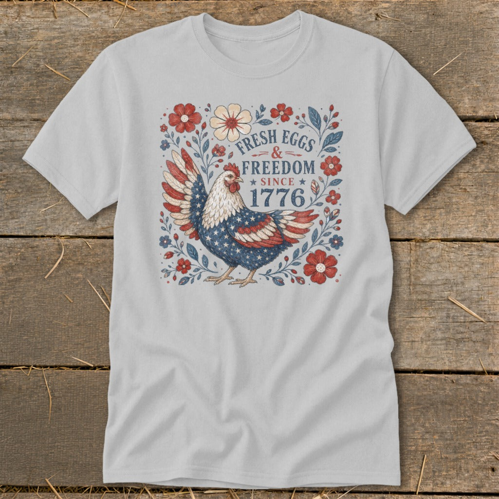 T-shirt with a patriotic chicken graphic and text "Fresh Eggs & Freedom Since 1776".