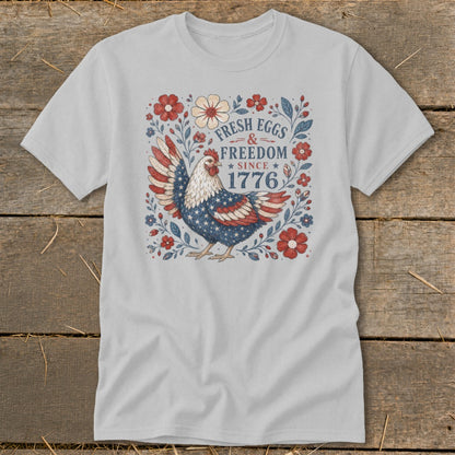 T-shirt with a patriotic chicken graphic and text "Fresh Eggs & Freedom Since 1776".