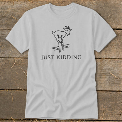 Light gray t-shirt with a black line drawing of a goat standing on a fence post and the text "JUST KIDDING".