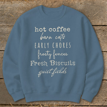 Blue sweatshirt with white text: "hot coffee, barn cats, early chores, frosty fences, Fresh Biscuits, quiet fields."