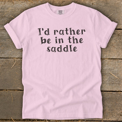 Pink t-shirt with "I'd rather be in the saddle" text.