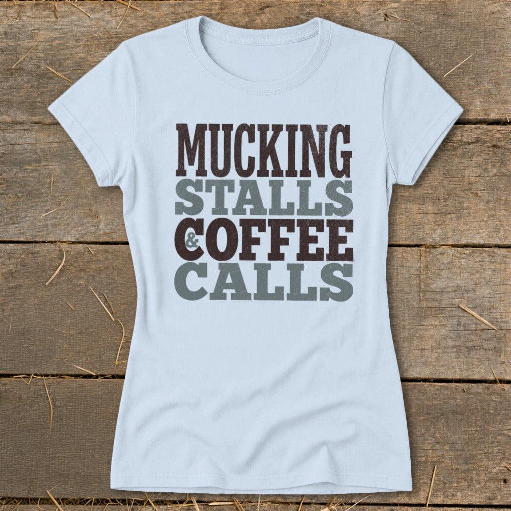 Light blue t-shirt with the text "Mucking Stalls & Coffee Calls" in dark brown and gray.
