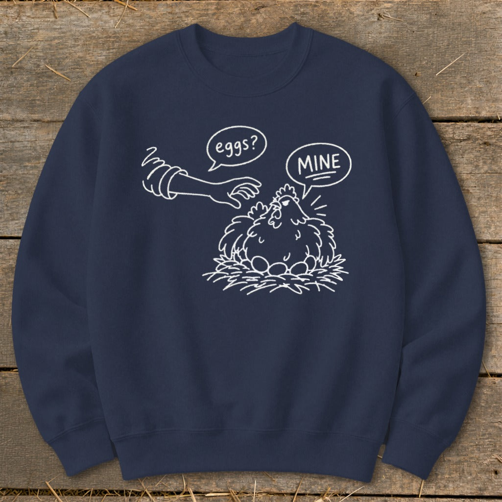 Navy sweatshirt with a white line drawing of a chicken protecting eggs, saying "MINE".