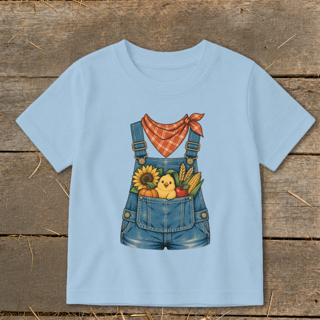 Light blue t-shirt with denim overalls graphic and fall harvest design.