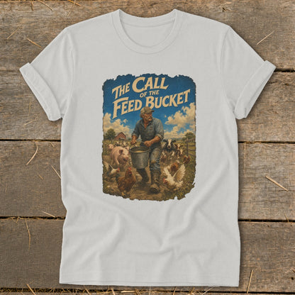 White t-shirt with graphic: farmer carrying feed bucket surrounded by farm animals and text "The Call of the Feed Bucket".