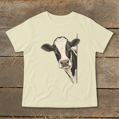 Cream t-shirt with a black and white cow peeking from the side.