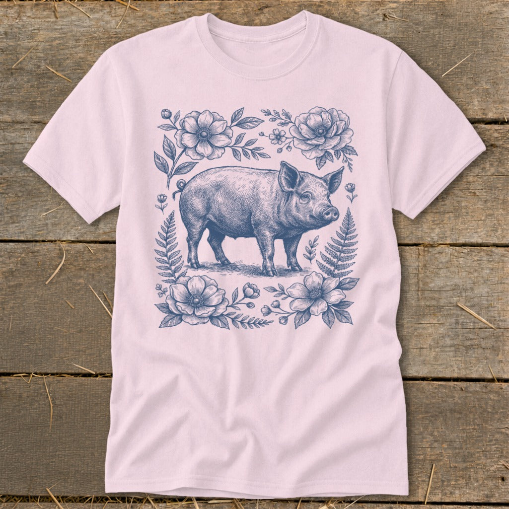 Pink t-shirt with a blue floral border and a pig illustration in the center.