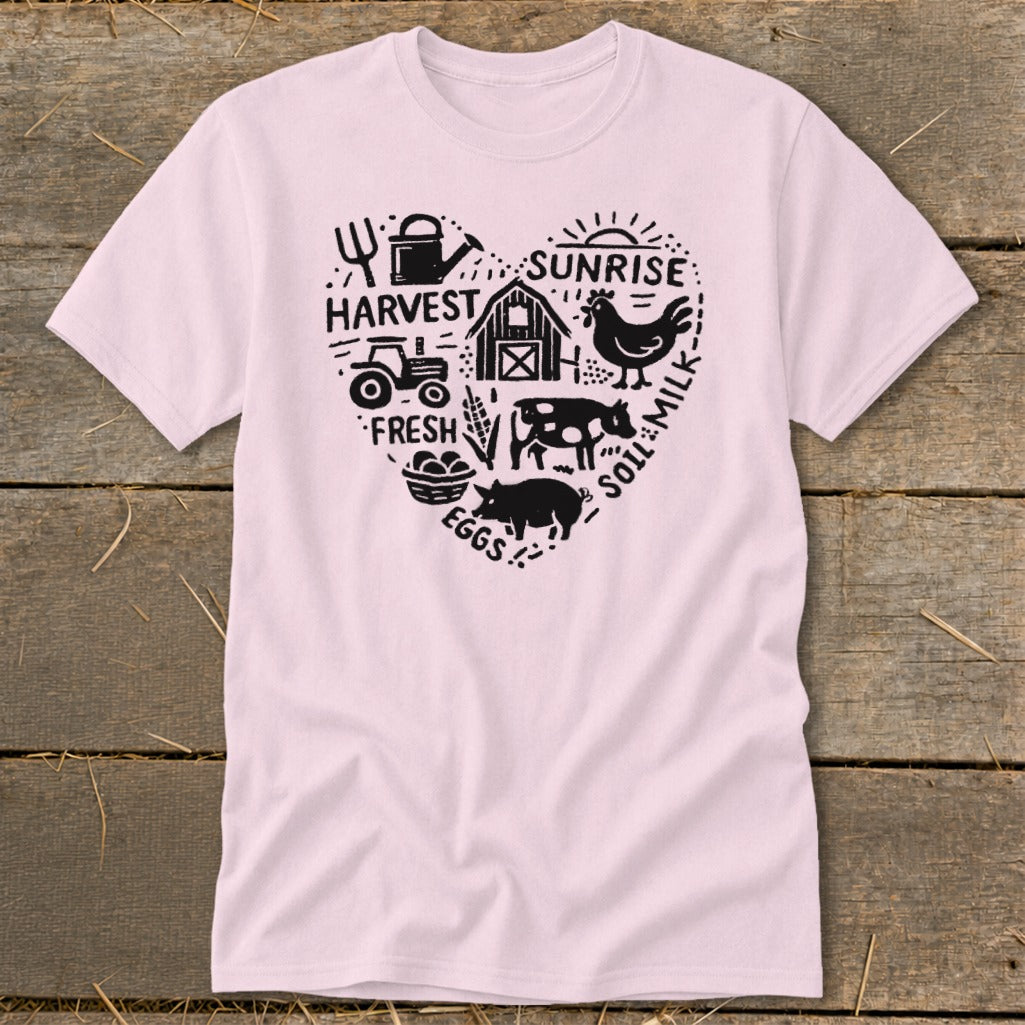 Pink t-shirt with a heart-shaped farm graphic including a tractor, barn, animals, and text.